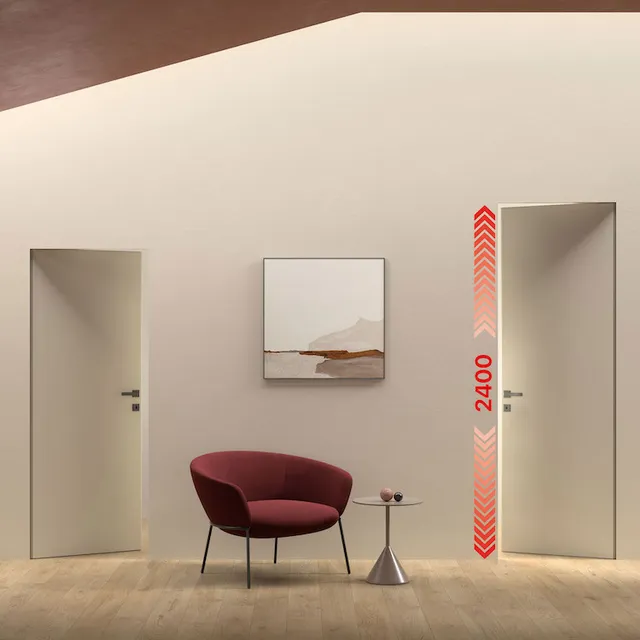 xREVERx XL Doppia porta battente filo muro reversibile su stessa parete. Entrambe le porte si aprono verso l'esterno, la porta di sinistra ha maniglia a destra, mentre la porta a destra ha maniglia a sinistra. L'ambiente è moderno con una poltrona robbo bordeaux al centro e la parete di riferimento comprese le porte è di colore beige.